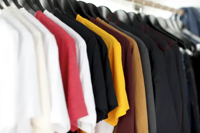 Curated neutral aesthetic capsule wardrobe rack with linen shirts blazer and boots