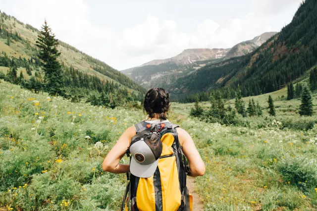 Hiker with backpack overlooking scenic mountain ridge