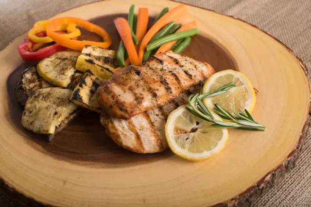 Juicy grilled chicken breasts sliced with fresh rosemary lemon and garlic