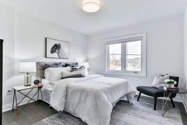 Plush five star hotel bed with crisp white linens fluffy pillows and waffle throw blanket