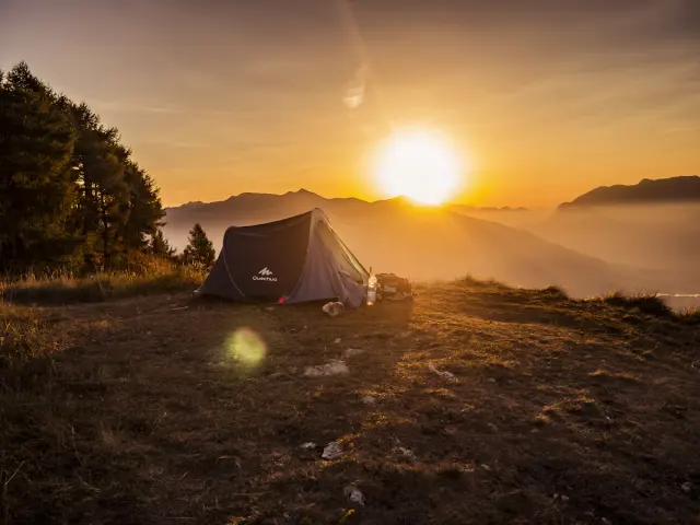 Cozy canvas glamping tent lit with warm string lights at dusk