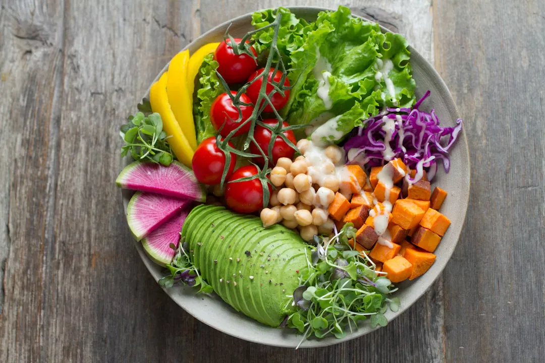 Colorful layered mason jar salads on kitchen counter with quinoa chickpeas and greens