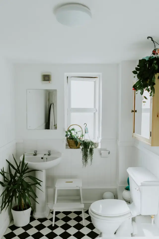 Modern small bathroom with organized glass jars wooden floating shelves and waffle towels