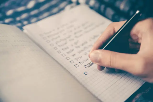 Fountain pen resting on minimalist daily to do checklist notebook with clean desk